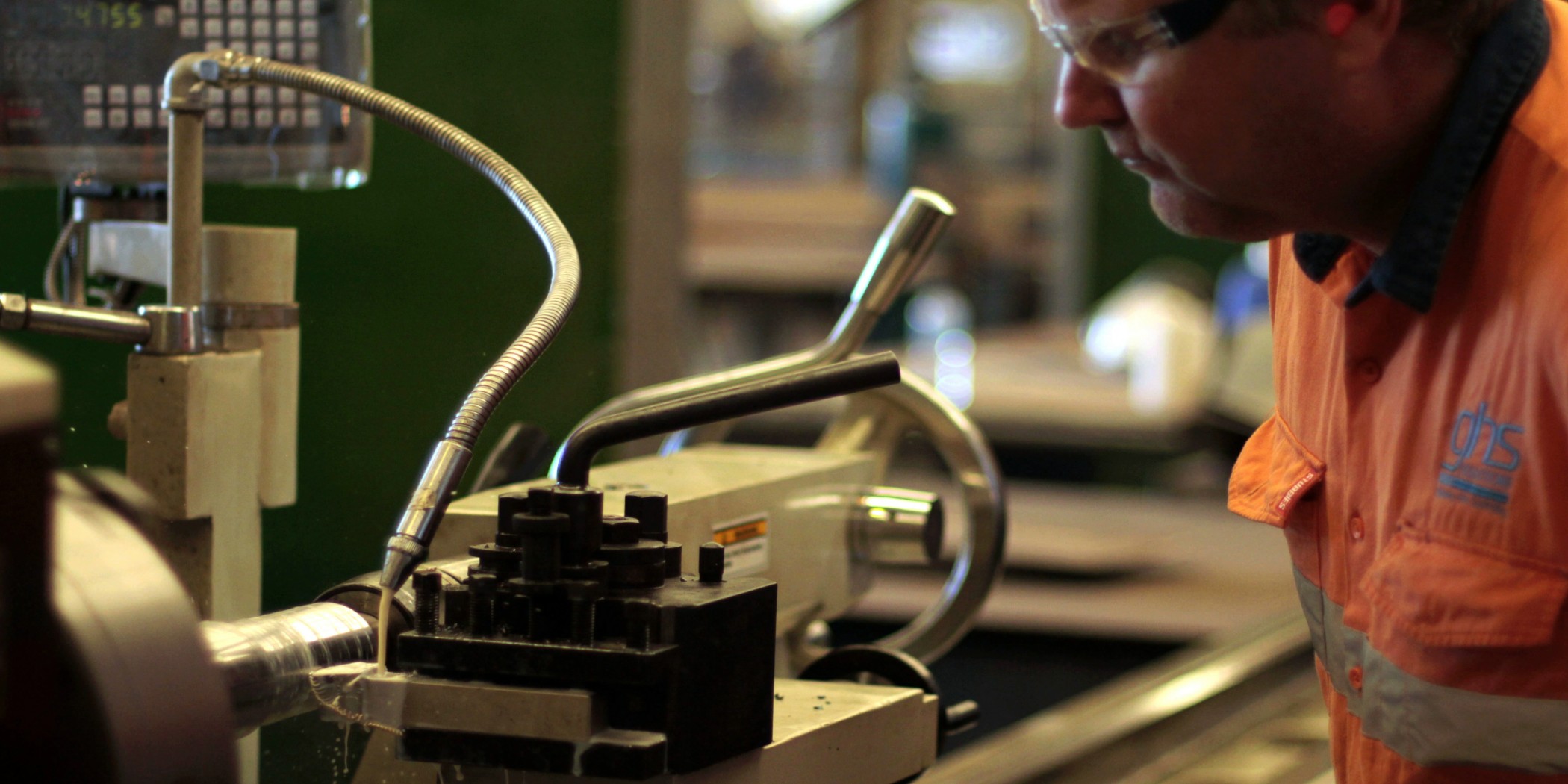 GHS employee using a metal lathe